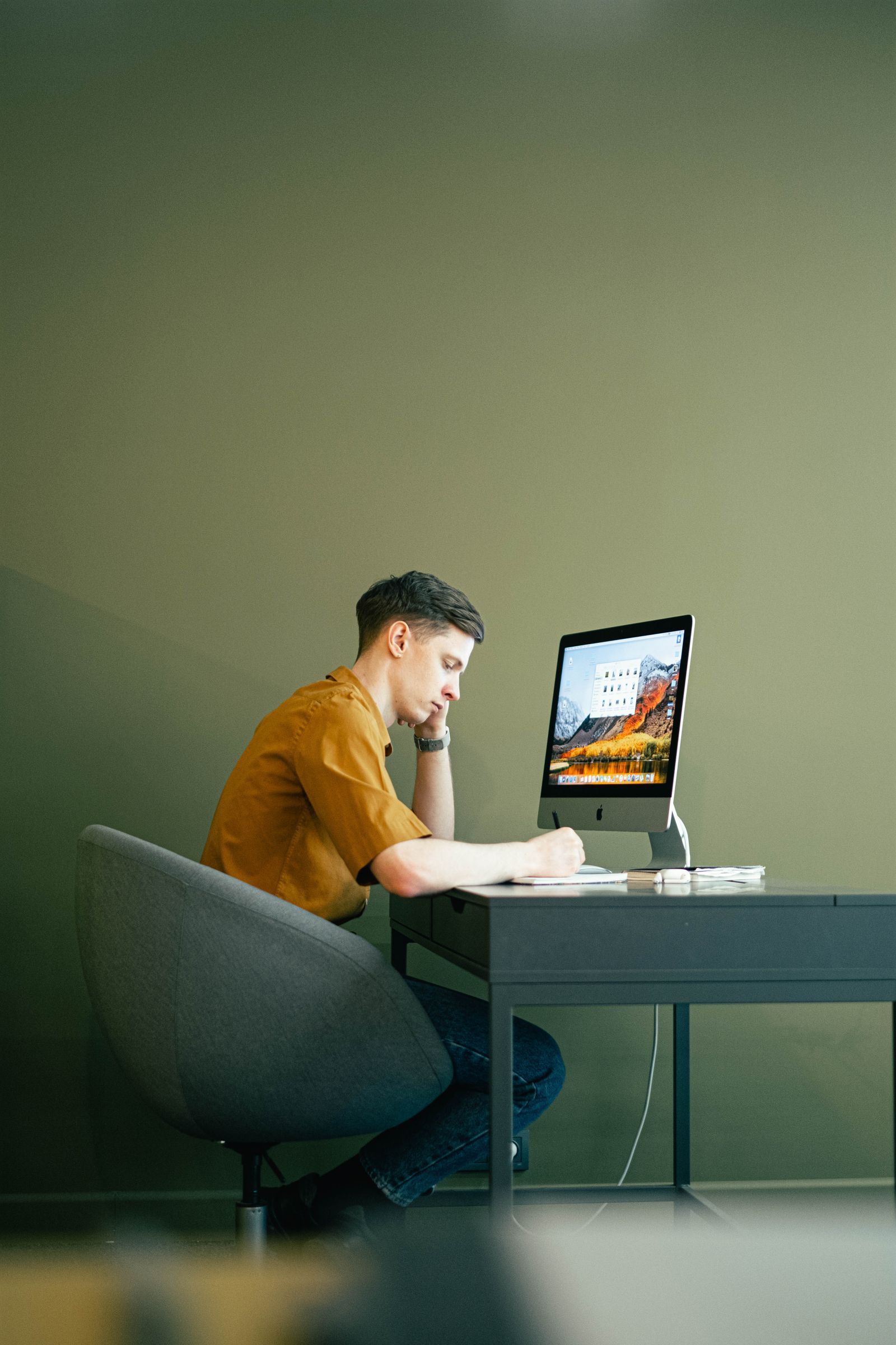Mann arbeitet konzentriert an seinem Schreibtisch