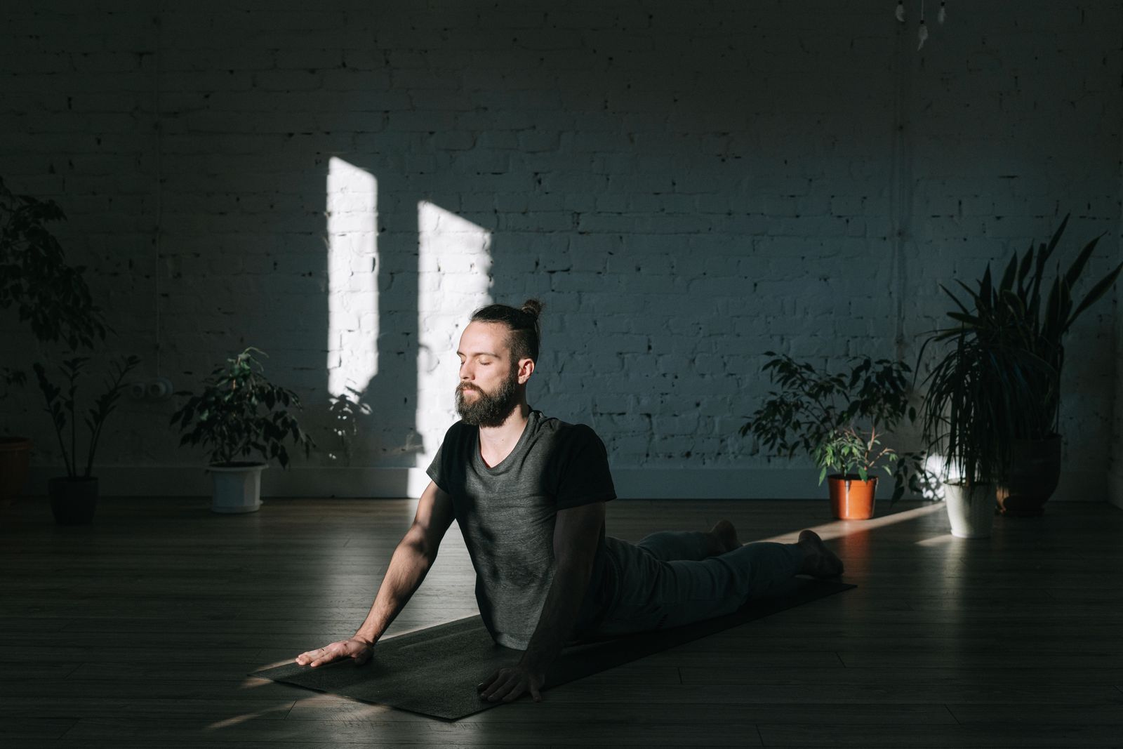 Mann entspannt in einer liegenden Yoga-Haltung mit Hilfsmitteln