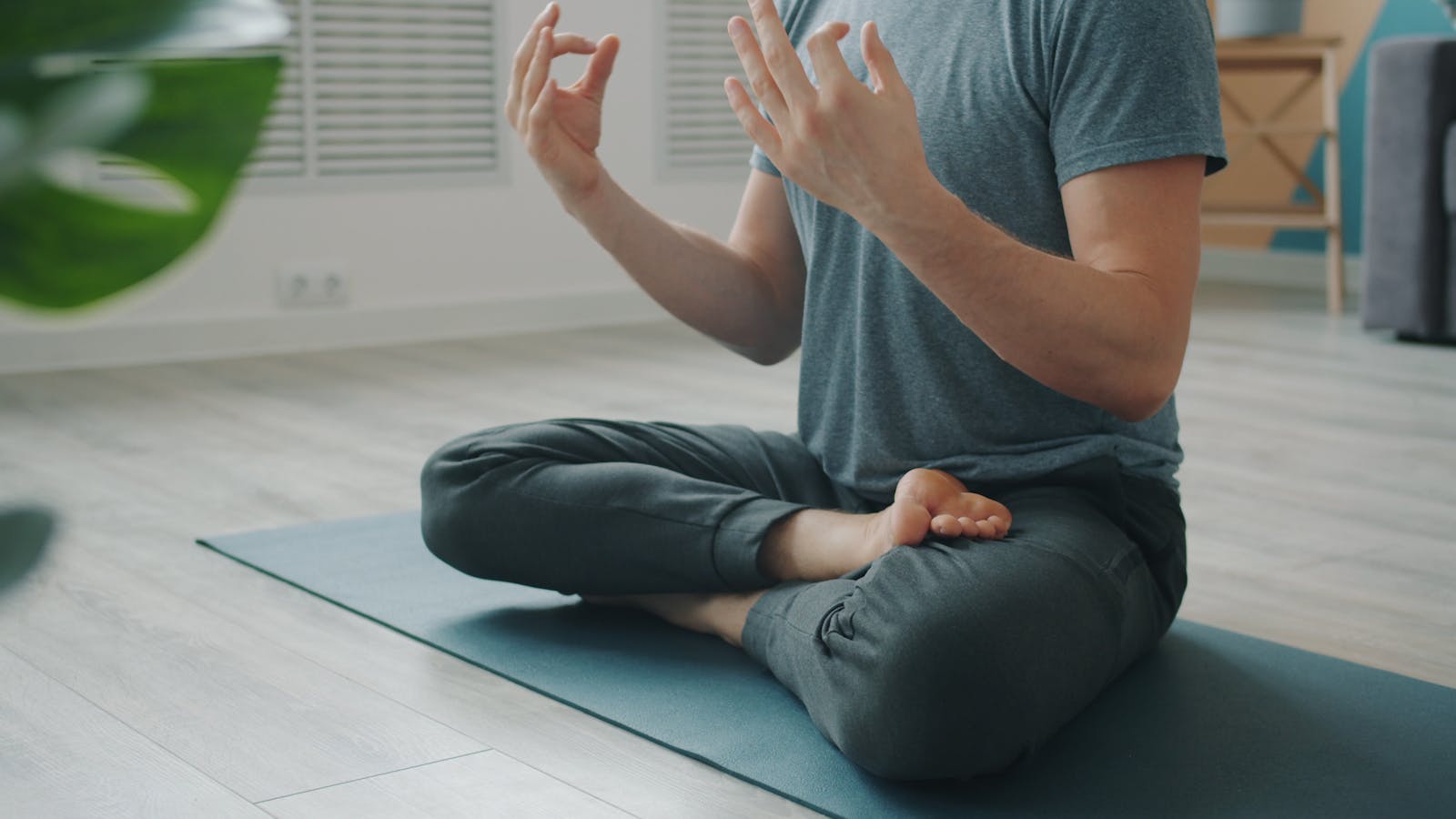 Mann auf der Yogamatte in einer ruhigen, sitzenden Haltung
